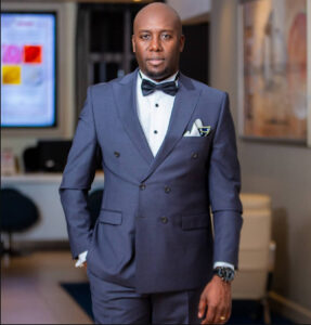 A picture of Dennis Okari in a suit